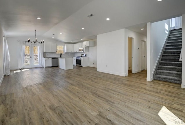 1436 Brewery Rd, Pueblo, CO 81001 - unfurnished living room featuring a chandelier, lofted ceiling, visible vents, and baseboards