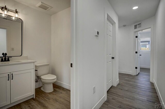 1436 Brewery Rd, Pueblo, CO 81001 - bathroom featuring visible vents, baseboards, wood finished floors, and toilet