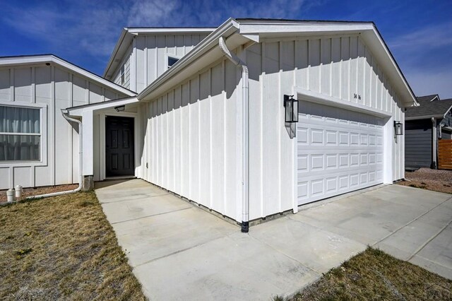 1436 Brewery Rd, Pueblo, CO 81001 - view of property exterior with board and batten siding, concrete driveway, and a garage