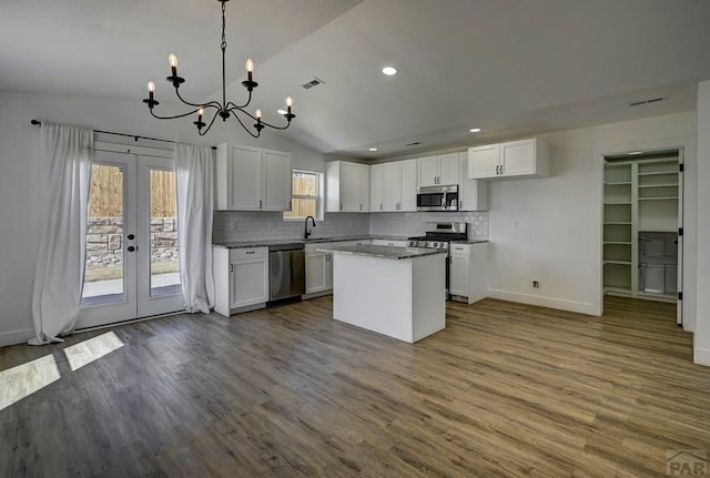 1436 Brewery Rd, Pueblo, CO 81001 - kitchen with white cabinets, visible vents, an inviting chandelier, lofted ceiling, and appliances with stainless steel finishes