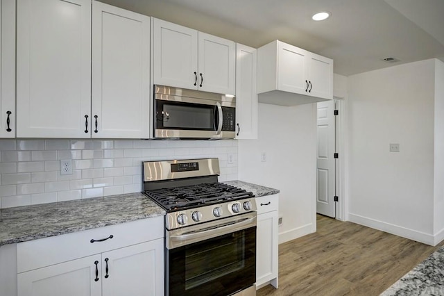 1436 Brewery Rd, Pueblo, CO 81001 - kitchen with light stone counters, visible vents, baseboards, and stainless steel appliances