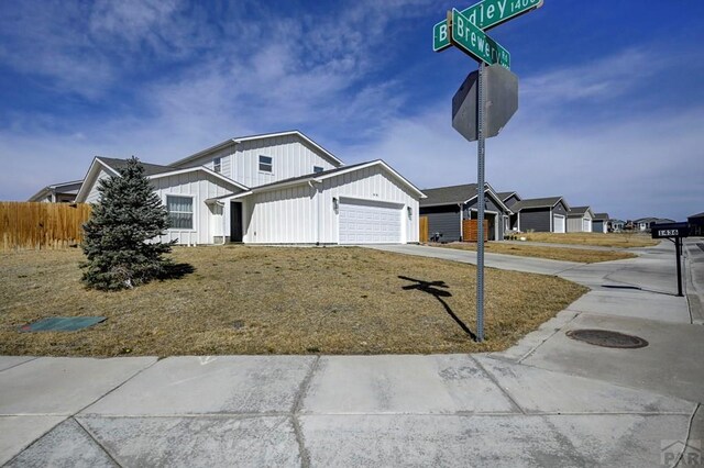 1436 Brewery Rd, Pueblo, CO 81001 - view of front facade featuring board and batten siding, an attached garage, concrete driveway, and fence