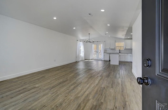 1436 Brewery Rd, Pueblo, CO 81001 - unfurnished living room featuring vaulted ceiling, wood finished floors, an inviting chandelier, and recessed lighting