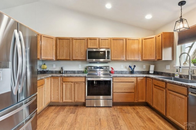 7470 Sun Prairie Dr, Fountain, CO 80925 - kitchen featuring stainless steel appliances, vaulted ceiling, light wood-style floors, dark countertops, and recessed lighting