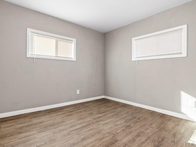 empty room featuring baseboards and wood finished floors