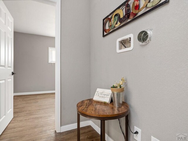 hall with baseboards and light wood-style floors