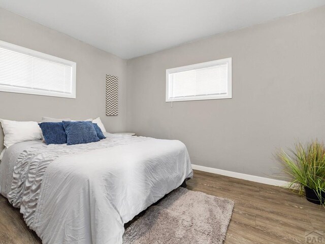 bedroom with baseboards and wood finished floors