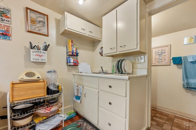 1609 Euclid Ave, Pueblo, CO 81004 - kitchen with baseboards, light countertops, and white cabinetry