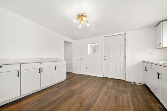 1609 Euclid Ave, Pueblo, CO 81004 - kitchen featuring white cabinetry, baseboards, visible vents, and dark wood-style floors