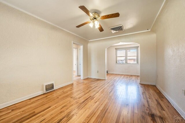 unfurnished room featuring crown molding, baseboards, visible vents, and light wood-style floors