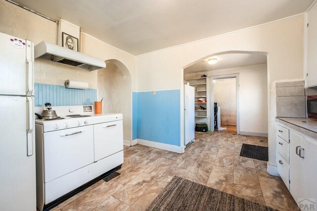 kitchen featuring white appliances, white cabinetry, and light countertops