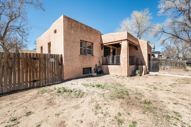 back of house featuring fence and stucco siding