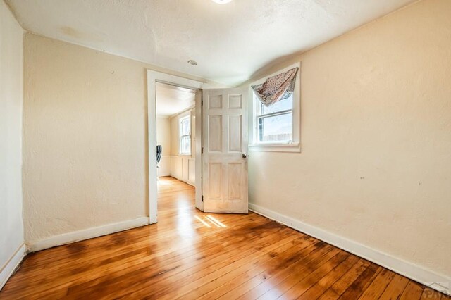 empty room with light wood-type flooring and baseboards