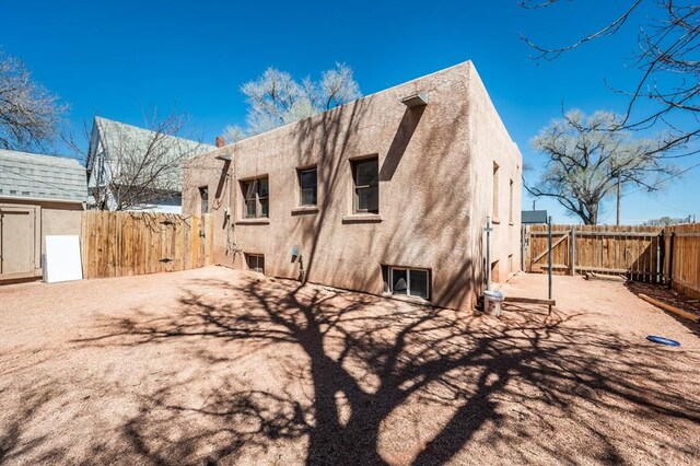 back of property featuring fence and stucco siding