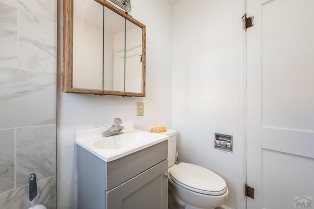 half bathroom with toilet and vanity