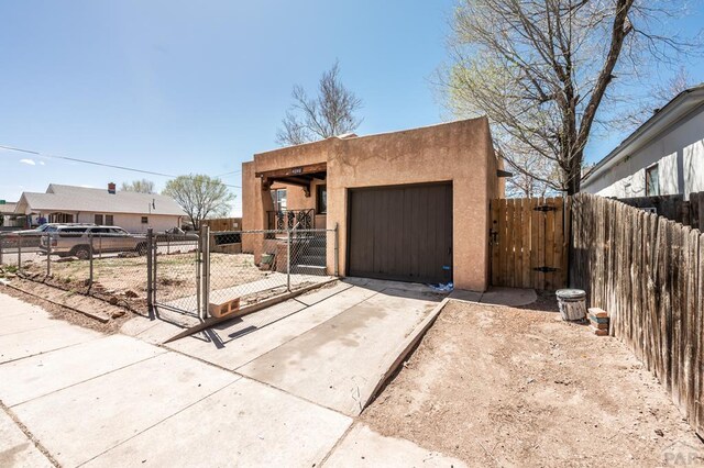 exterior space featuring a gate, fence, and concrete driveway