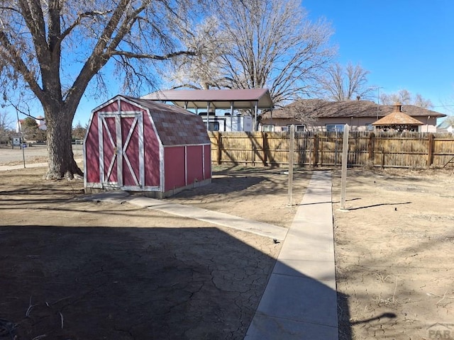 view of yard with an outbuilding, a storage unit, and fence