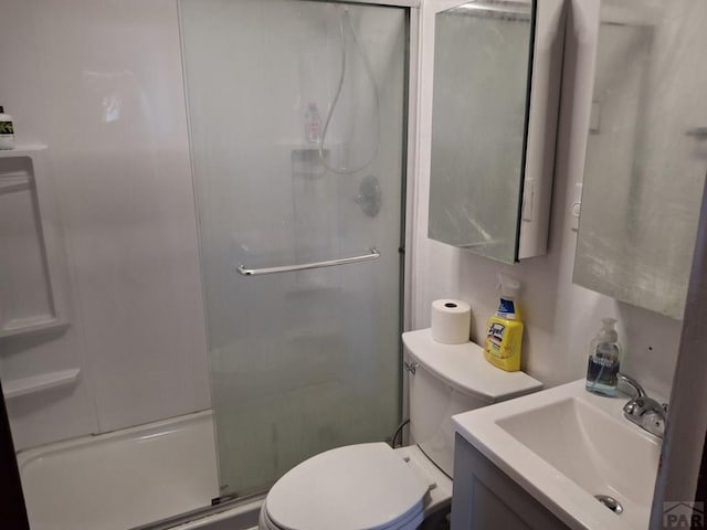 full bathroom with toilet, a stall shower, and vanity