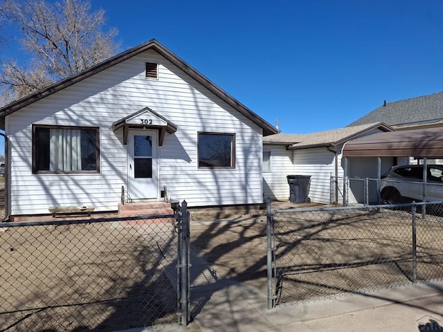 view of front of house featuring entry steps, a fenced front yard, a gate, and a carport