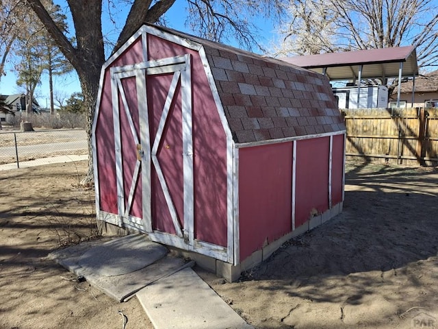 view of shed featuring fence