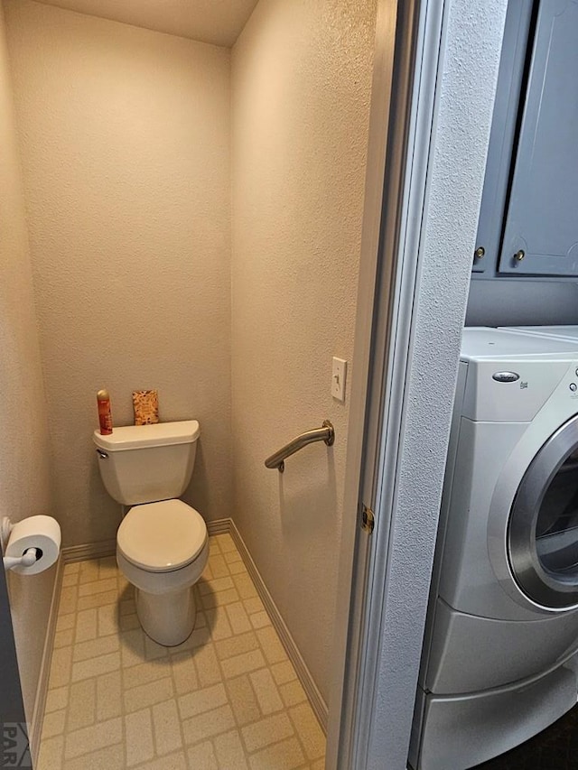 743 G St, Two Buttes, CO 81084 - bathroom featuring washer / clothes dryer, toilet, and baseboards