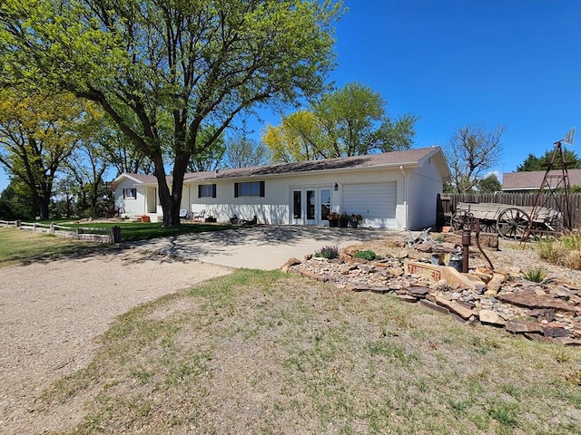 743 G St, Two Buttes, CO 81084 - ranch-style house featuring french doors, driveway, an attached garage, and stucco siding