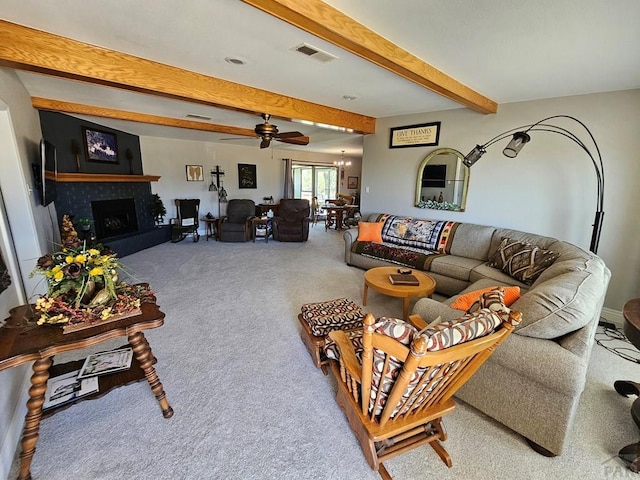 743 G St, Two Buttes, CO 81084 - living area featuring beamed ceiling, carpet, ceiling fan, a fireplace with raised hearth, and a chandelier