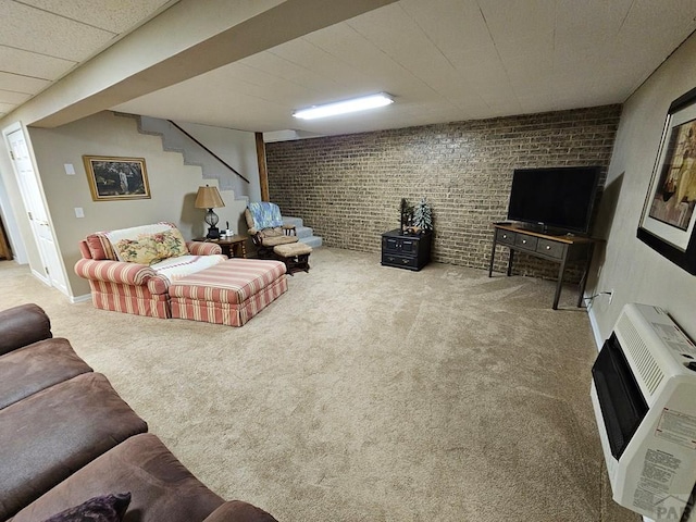 743 G St, Two Buttes, CO 81084 - living room featuring heating unit, carpet floors, brick wall, and stairway