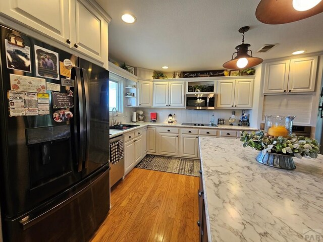 743 G St, Two Buttes, CO 81084 - kitchen with black appliances, open shelves, a sink, light wood-style flooring, and recessed lighting