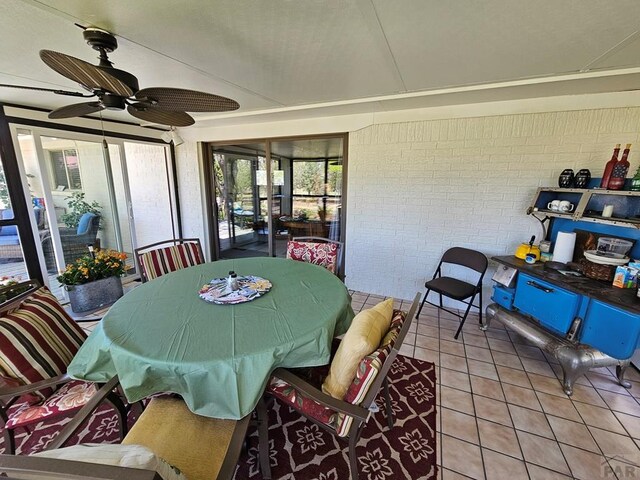 743 G St, Two Buttes, CO 81084 - sunroom featuring brick wall, ceiling fan, tile patterned flooring, and outdoor dining area