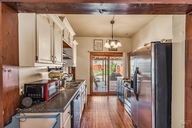 715 E 8th St, Pueblo, CO 81001 - kitchen with stainless steel appliances, dark wood-type flooring, a sink, dark countertops, and white cabinetry