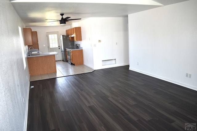 1417 Bradish Ave, La Junta, CO 81050 - kitchen with stainless steel appliances, a sink, wood finished floors, a ceiling fan, and brown cabinets