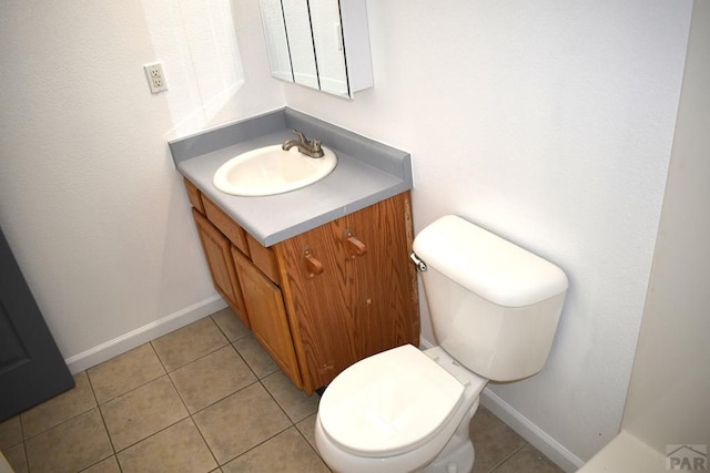 1417 Bradish Ave, La Junta, CO 81050 - half bathroom with vanity, toilet, tile patterned flooring, and baseboards