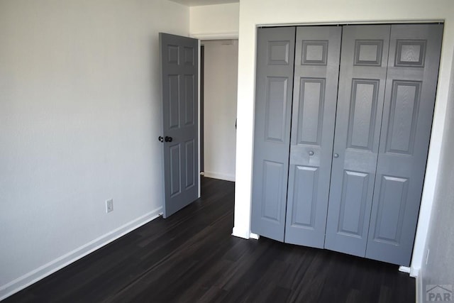 1417 Bradish Ave, La Junta, CO 81050 - unfurnished bedroom featuring dark wood-style floors, baseboards, and a closet