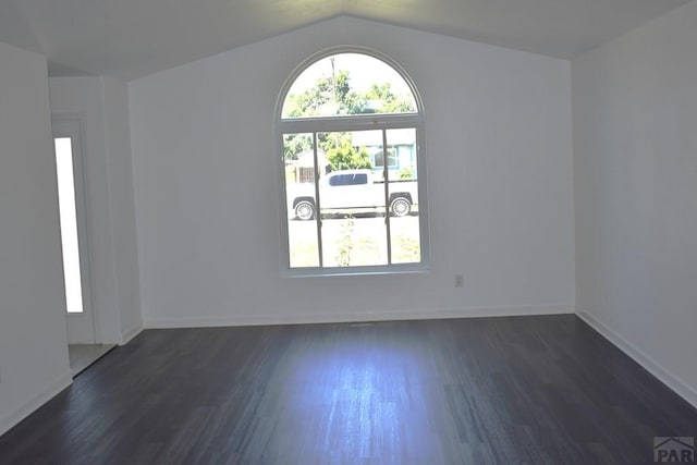 1417 Bradish Ave, La Junta, CO 81050 - unfurnished room with dark wood-type flooring, lofted ceiling, and baseboards