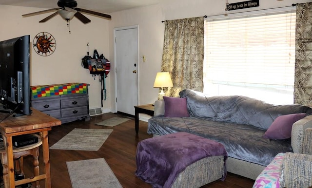 living room with visible vents, dark wood finished floors, baseboards, and ceiling fan