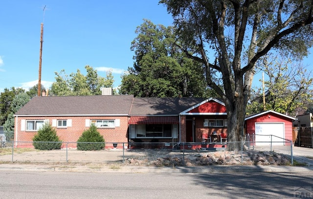 ranch-style home with a fenced front yard, brick siding, a detached garage, crawl space, and driveway