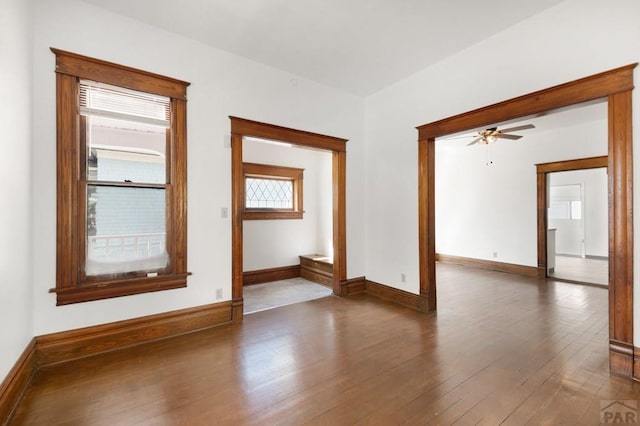 spare room featuring hardwood / wood-style floors, baseboards, and ceiling fan