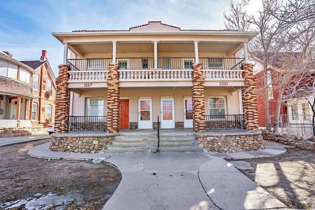 view of front of house with a balcony and stucco siding