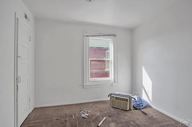 empty room featuring cooling unit, wood finished floors, a ceiling fan, baseboards, and a wall mounted air conditioner