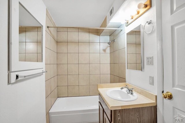 bathroom with tub / shower combination, visible vents, and vanity