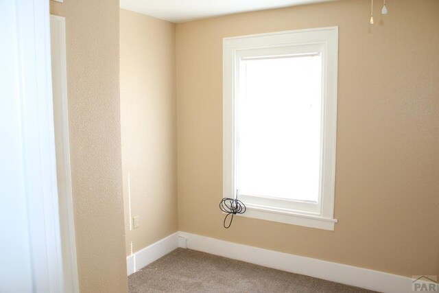 empty room featuring a baseboard heating unit, carpet flooring, and a ceiling fan