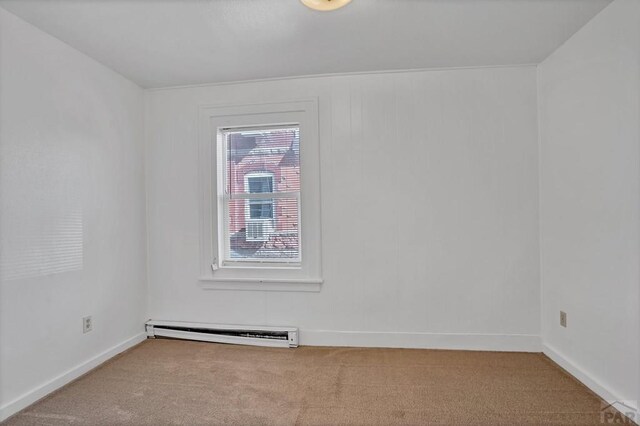 unfurnished room with carpet floors, a baseboard radiator, and baseboards