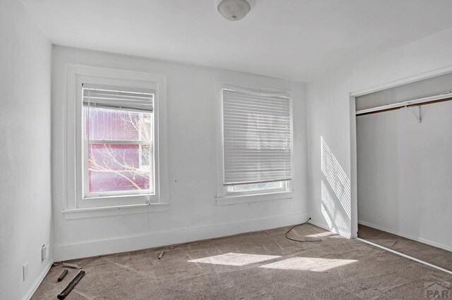 bedroom with a closet, light wood-style flooring, and baseboards