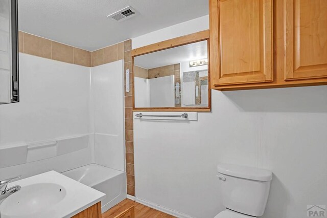 full bath with toilet, bathtub / shower combination, vanity, and visible vents