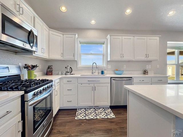 439 N Mitford Dr, Pueblo West, CO 81007 - kitchen with appliances with stainless steel finishes, a sink, white cabinetry, dark wood-style flooring, and light countertops
