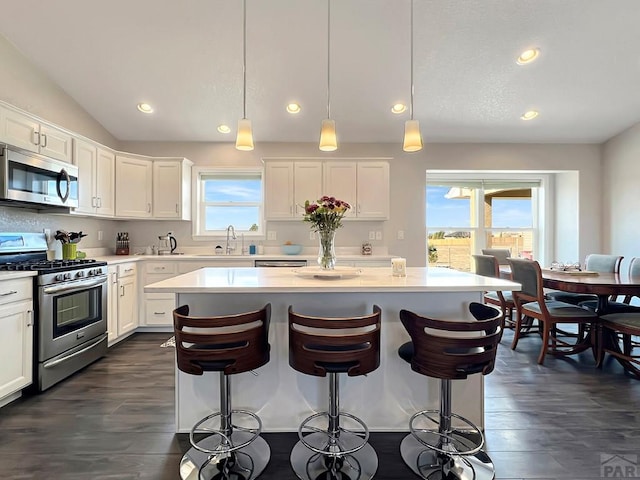 439 N Mitford Dr, Pueblo West, CO 81007 - kitchen featuring stainless steel appliances, a kitchen island, light countertops, white cabinets, and dark wood finished floors