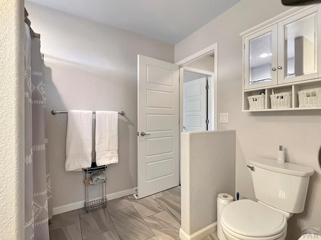 439 N Mitford Dr, Pueblo West, CO 81007 - full bathroom featuring toilet, baseboards, and marble look tile flooring