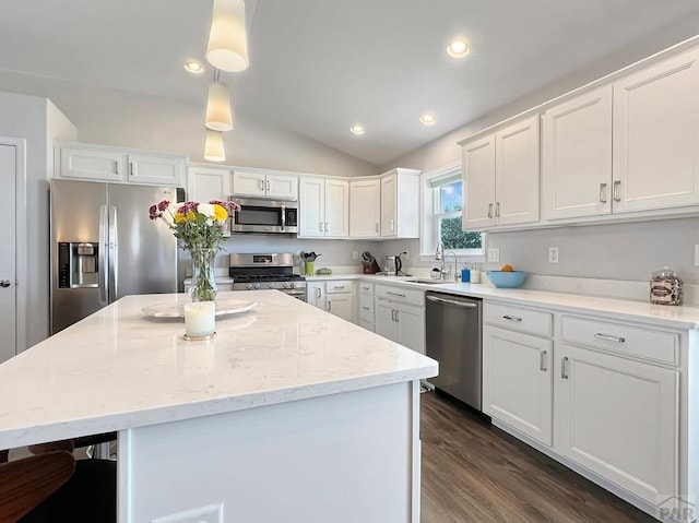 439 N Mitford Dr, Pueblo West, CO 81007 - kitchen with stainless steel appliances, white cabinets, a center island, a sink, and lofted ceiling