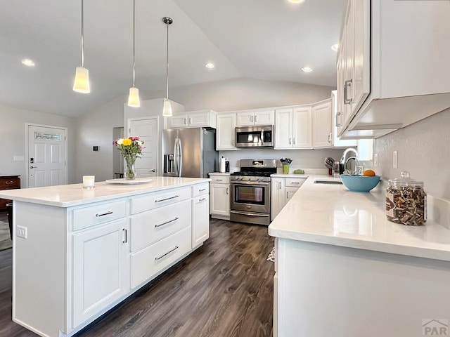 439 N Mitford Dr, Pueblo West, CO 81007 - kitchen with stainless steel appliances, a sink, vaulted ceiling, a center island, and white cabinetry